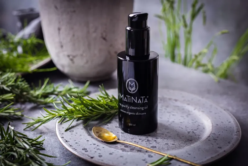 Matinata re.purify cleansing oil on a stone plate with fresh rosemary and a golden spoon of oil